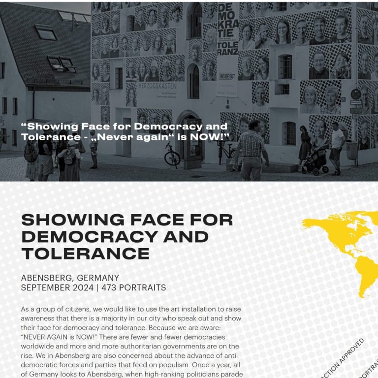 Großes Gebäude mit vielen Porträtfotos an der Fassade, davor mehrere Personen, eine mit Kinderwagen.